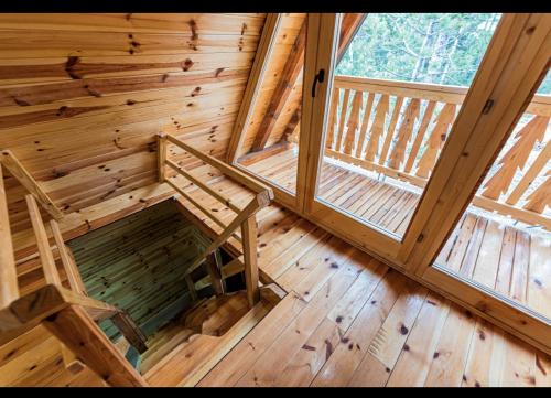 an inside view of a log cabin with a bench and two windows at Kovacevic Weekend House in Lokva