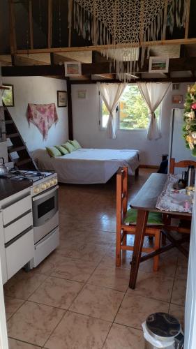 a kitchen with a stove and a bed in a room at Mana in San Martín de los Andes
