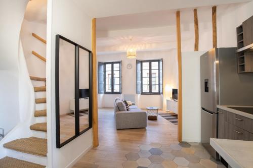 ein Wohnzimmer mit einem Sofa und einem Spiegel in der Unterkunft Le Duplex - Hypercentre - Wifi in Carpentras