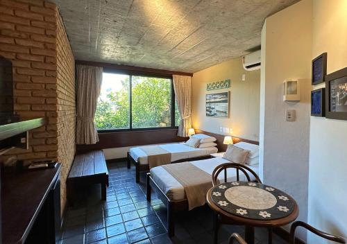 a hotel room with two beds and a table at Hotel Catharina Paraguaçu in Salvador