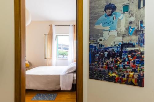 Punto Felice Stadio في نابولي: غرفة نوم بسرير ودهان على الحائط