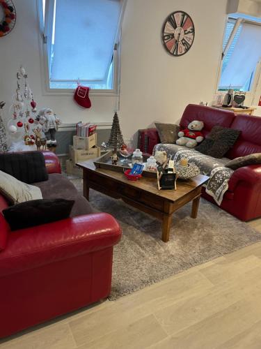 ein Wohnzimmer mit einem roten Sofa und einem Couchtisch in der Unterkunft chambres de la Nonette in Senlis