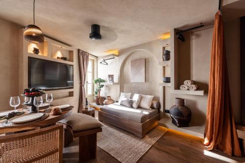 - un salon avec un canapé et une télévision dans l'établissement WABISABI SUITES - MÉRO, à Cannes
