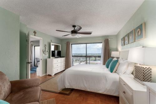 a bedroom with a bed and a ceiling fan at Beach views with top complex amenities and covered parking! in Ormond Beach