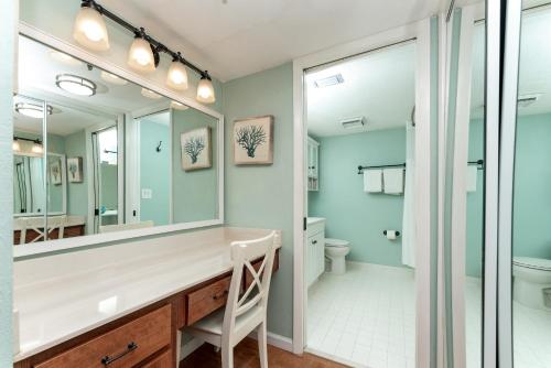a bathroom with a sink and a mirror at Beach views with top complex amenities and covered parking! in Ormond Beach