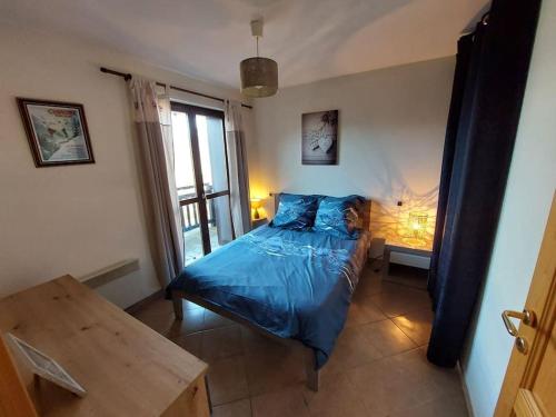 - une chambre avec un lit bleu et une table dans l'établissement Appartement Saint Gervais proche centre, à Saint-Gervais-les-Bains