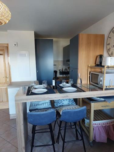 une cuisine avec un comptoir avec deux lavabos et des tabourets bleus dans l'établissement Appartement Saint Gervais proche centre, à Saint-Gervais-les-Bains