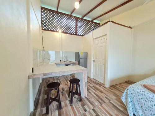 cocina con 2 taburetes y barra en una habitación en Apartamentos Sol, en Cahuita