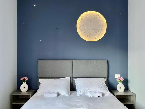 a bedroom with a bed with a large moon on the wall at Cozy Hideout - Condo Hotel in Timişoara