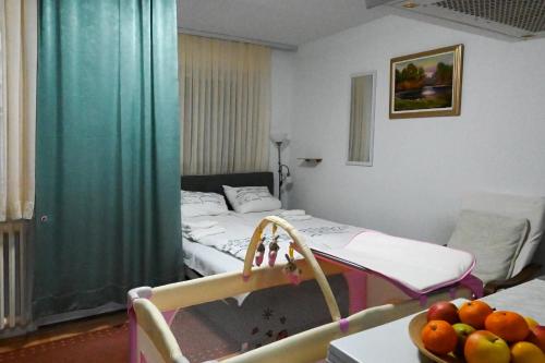 una camera con letto e tavolo con un cesto di frutta di Studio apartman Dora a Vinkovci