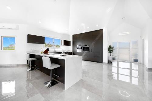 a white kitchen with a large island in a room at Lovely 4-Bed Villa in Anguilla in Long Path