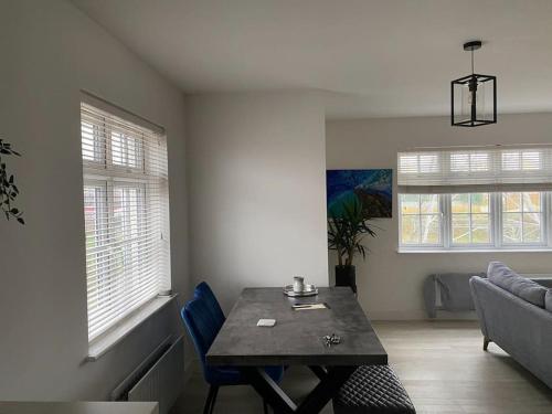 een woonkamer met een tafel en een bank bij Beautiful Modern Tranquil Two Bedroom Apartment in Swanscombe