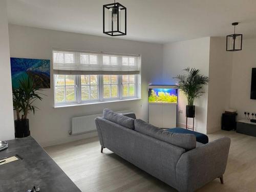 a living room with a couch and a fish tank at Beautiful Modern Tranquil Two Bedroom Apartment in Swanscombe