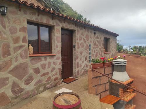 Casa de piedra con puerta y ventana en Casa las montañas de Anaga, en La Laguna