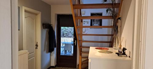 uma casa de banho com uma escada ao lado de uma cozinha com um lavatório em Tranquility - Your home Away em Grez-Doiceau