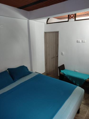 Descanso y tranquilidad في سانتا في دي أنتيوكيا: غرفة نوم بسرير ازرق وطاولة