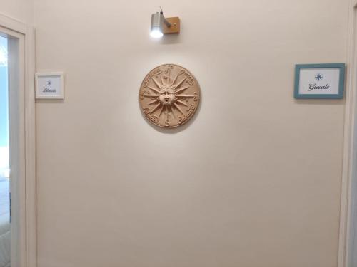 a clock on a wall next to a door at B&B Vento Aureo Rooms in Milazzo