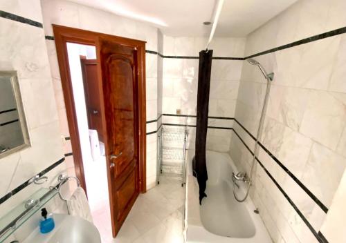 een badkamer met een bad en een wastafel bij Vue Mer Époustouflante in La Goulette