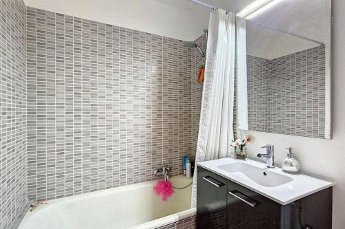 La salle de bains est pourvue d'un lavabo et d'une baignoire. dans l'établissement Spacieux studio à 150m de la plage 2 terrasses, à Antibes