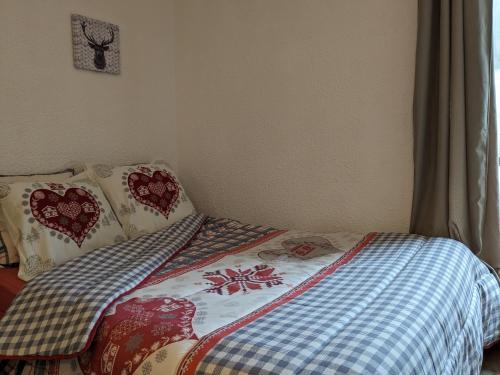 - un lit avec une couverture et des oreillers dans une chambre dans l'établissement studio terrasse de charme près des pistes, à Bernex