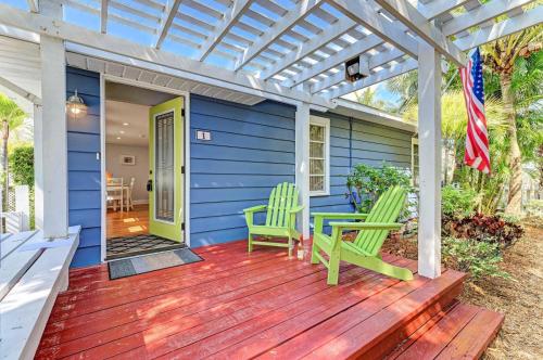 a blue house with green chairs and a wooden deck at Slo M'Ocean in Anna Maria