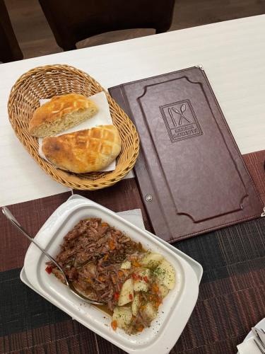 een tafel met een bord eten en een mand brood bij 9 mezeta in Pirot