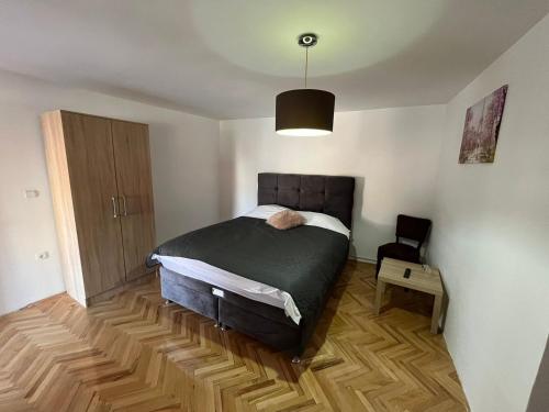 een slaapkamer met een bed en een houten vloer bij 9 mezeta in Pirot