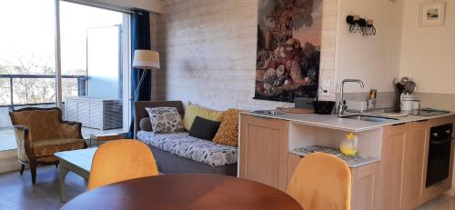 cocina y sala de estar con mesa y sillas en Les Terrasses Plage Benoit, en La Baule