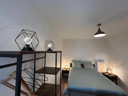 ein Schlafzimmer mit einem Bett und einem Tisch mit Lampen in der Unterkunft Dream Paris Maisons-Alfort in Maisons-Alfort