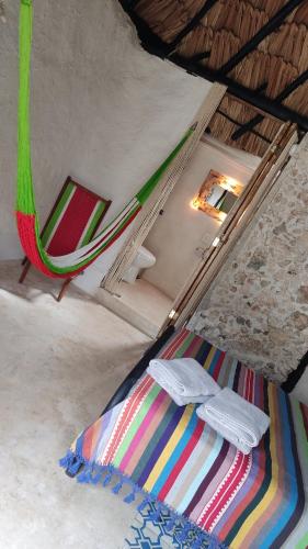 1 dormitorio con 1 cama y 1 hamaca en una habitación en Casa Maya Tolok - Alberca - Wifi-Starlink - Tour Sustentabilidad, en Izamal
