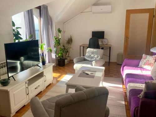 uma sala de estar com sofás e uma televisão de ecrã plano em Apartment Kvadar em Banja Luka