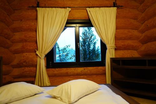 1 dormitorio con cama y ventana en Mi Chalet, en Vatra Dornei