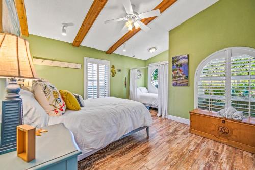 a bedroom with green walls and a bed with a ceiling fan at Buttonwood Cottage in Anna Maria