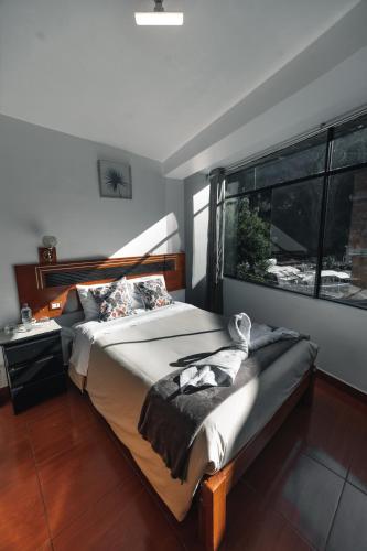 a bedroom with a bed and a large window at Escobedo’s Inn Machupicchu in Machu Picchu
