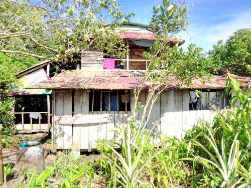 an old white house with a rusty roof at Hostal Atrapasueños playa La Barra in Buenaventura