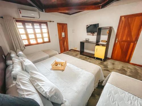 ein Schlafzimmer mit einem großen weißen Bett und einem TV in der Unterkunft Pousada Castanho in Delmiro Gouveia