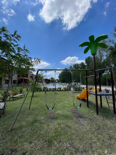 une balançoire dans un parc avec une aire de jeux dans l'établissement Altos de la Cañada, à Pilar