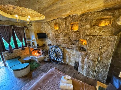 sala de estar con pared de piedra y chimenea en Anilia Guesthouse en Synikia Mesi Trikalon