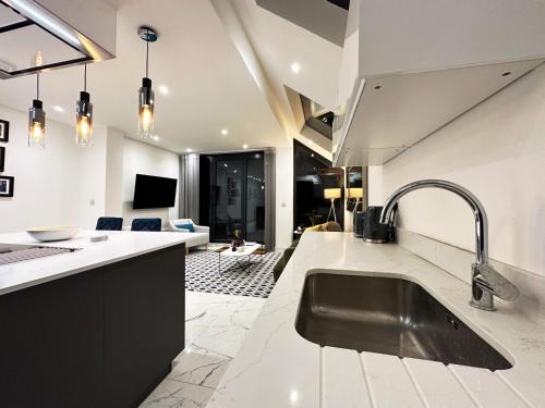a kitchen with a sink and a living room at Nancys Place in Notting Hill hosted by AirOperate in London