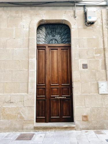 a wooden door on a brick building with a stone wall at EL RINCÓN del TOLOÑO in Haro