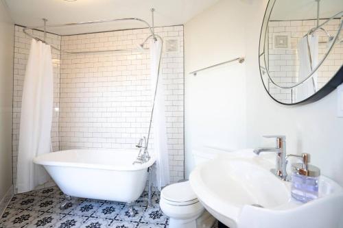 丹佛的住宿－The Grand Curtis，白色的浴室设有浴缸、卫生间和水槽。