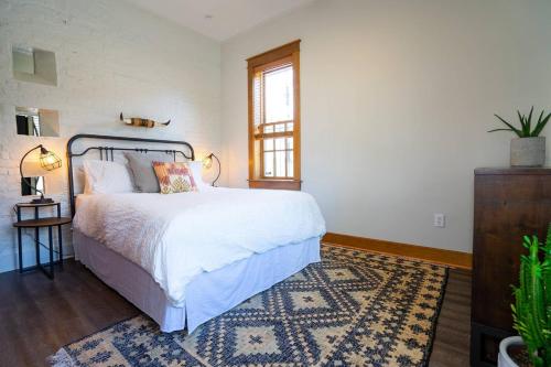 a bedroom with a white bed and a rug at The Grand Curtis in Denver