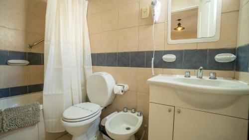 a small bathroom with a toilet and a sink at Apart del Golfo in Las Grutas