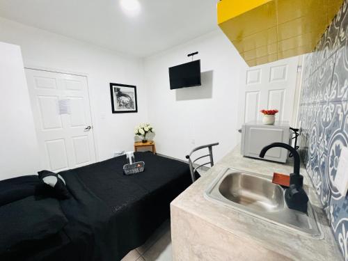 a kitchen with a sink and a bed in a room at CASA AMBAR in Tijuana