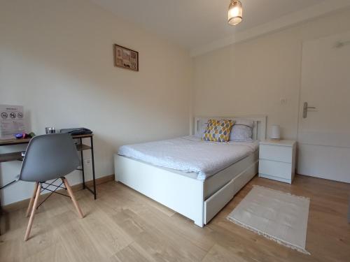 um quarto com uma cama, uma secretária e uma cadeira em Chez François: appartement 3 chambres 4 personnes em Saint-Avold