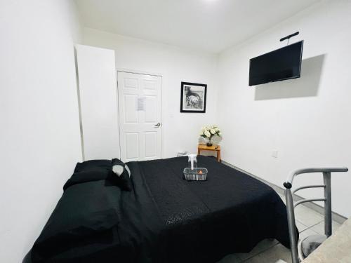 a bedroom with a bed with a black blanket at CASA AMBAR in Tijuana