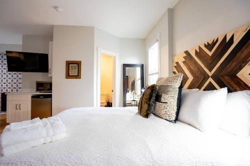 Schlafzimmer mit einem weißen Bett mit einem Kopfteil aus Holz in der Unterkunft Notorious Outlaw in Denver