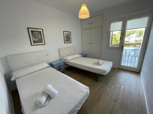 1 dormitorio con 2 camas y ventana en Sa Posta, en Cala en Forcat