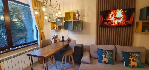 FOX boutique apartment Borovets Gardens في بوروفتس: غرفة معيشة مع أريكة وطاولة ومدفأة