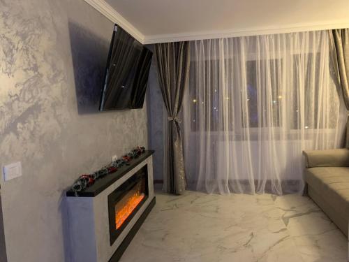 a living room with a fireplace in front of a window at Palas Ultraconfort in Iaşi